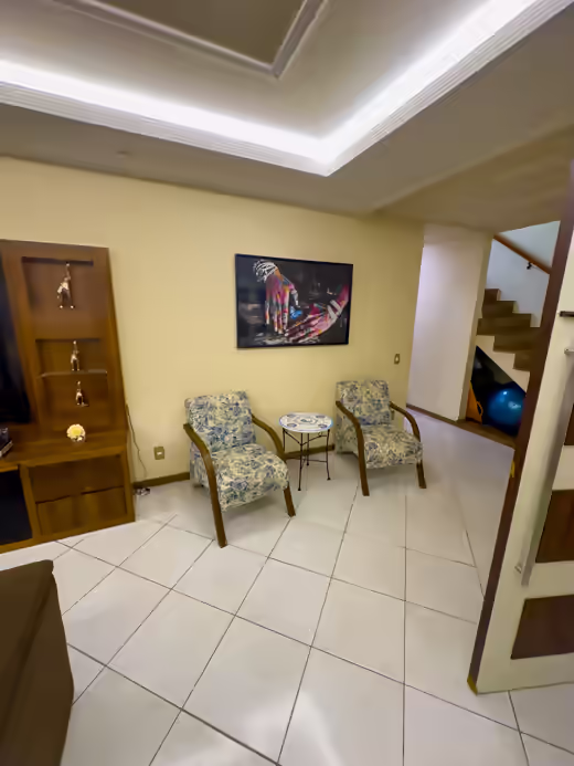Sala de estar com poltronas e escada