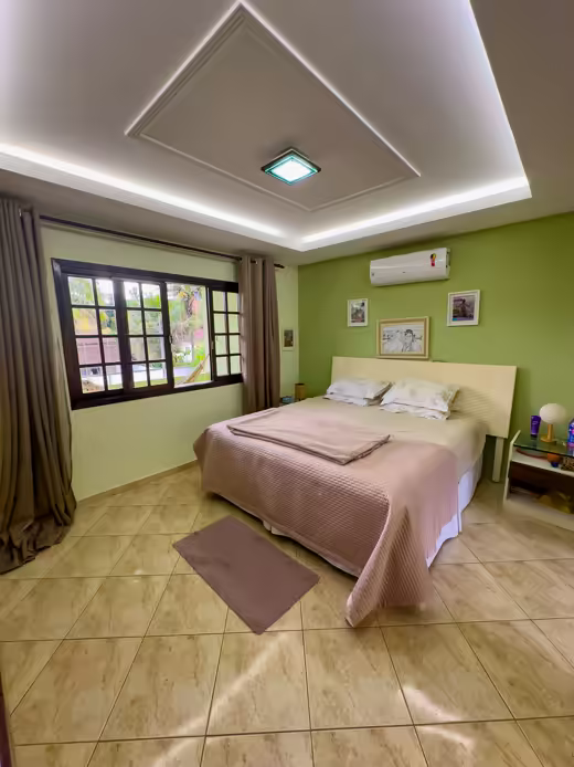 Suíte 1: quarto principal com cama e janela