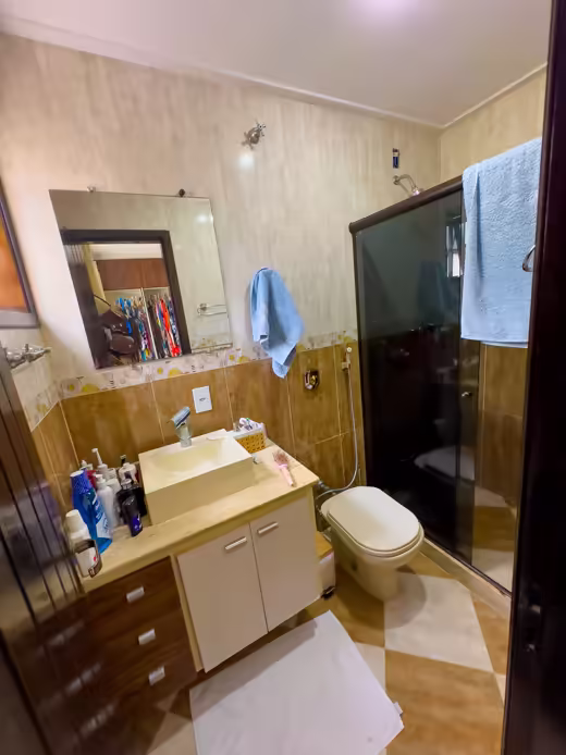 Suíte 1: banheiro com box escuro e bancada